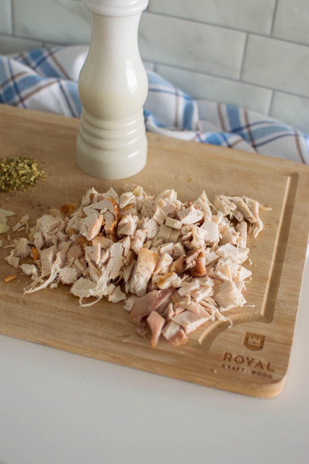 Precooked chicken, cut into small pieces on a wooden cutting board