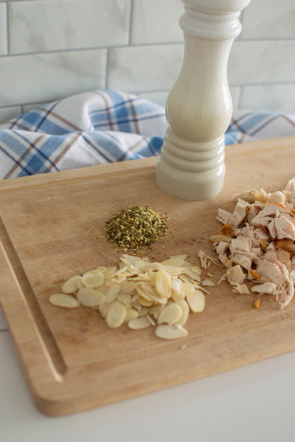 Ingredients required to make our easy chicken salad recipe, laid out on a wooden cutting board