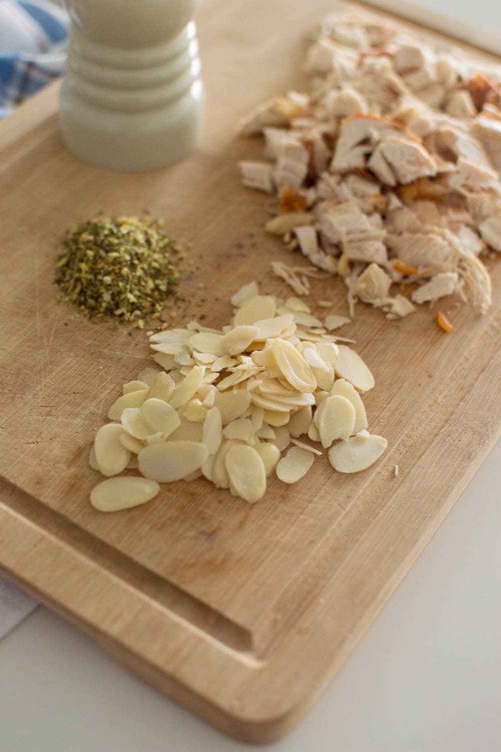 Ingredients required to make our easy chicken salad recipe, laid out on a wooden cutting board