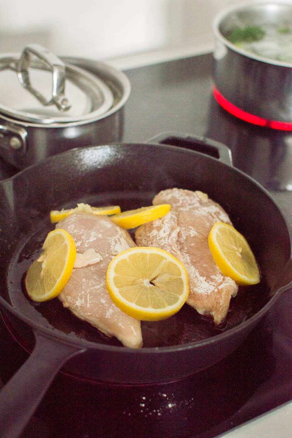 Cooking chicken with lemon on a cast iron skillet