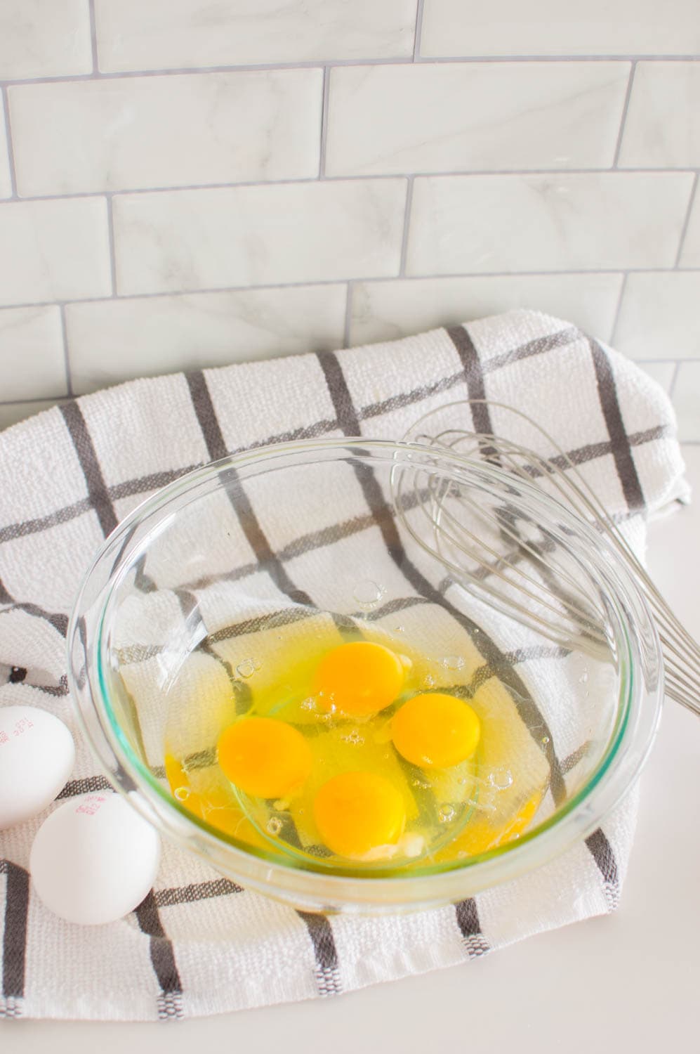 4 eggs in a glass bowl, ready to be whipped to make easy scrambled eggs
