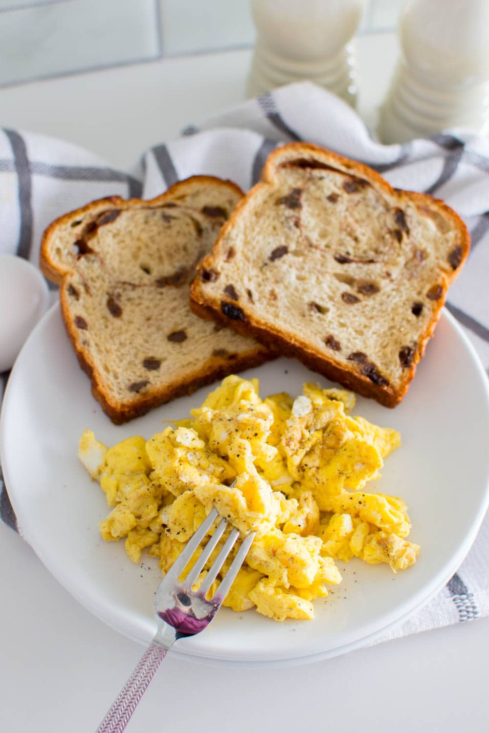 Aerial view of scrambled eggs, homemade and accompanied by raisin bread