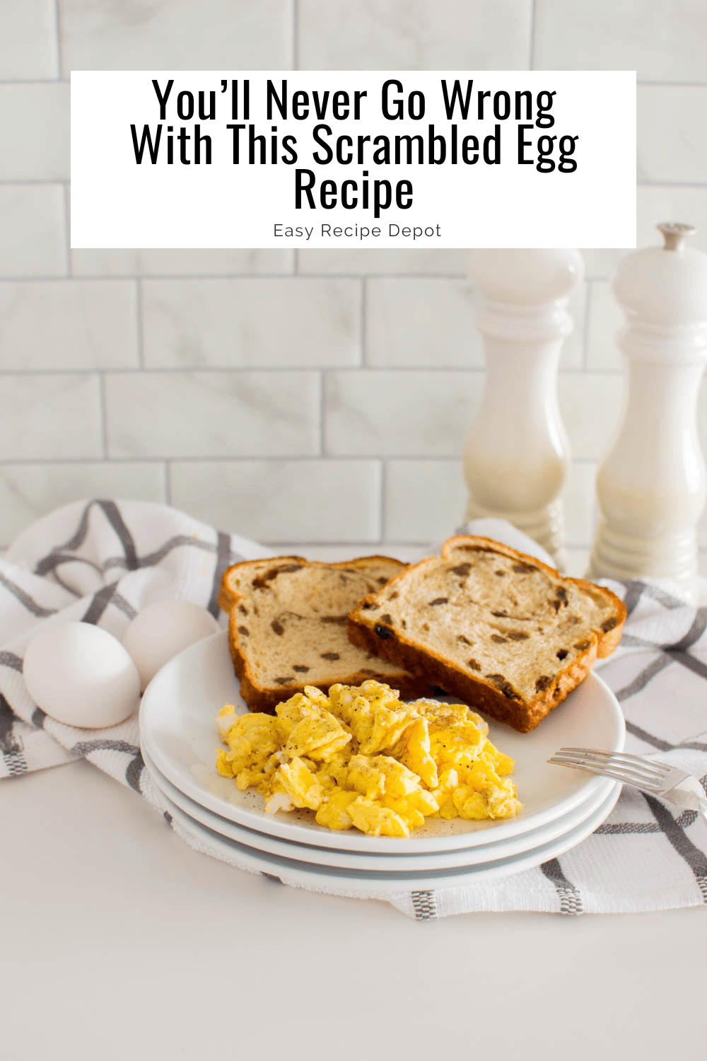Easy Scrambled Eggs on a stack of white plates, accompanied by raisin bread