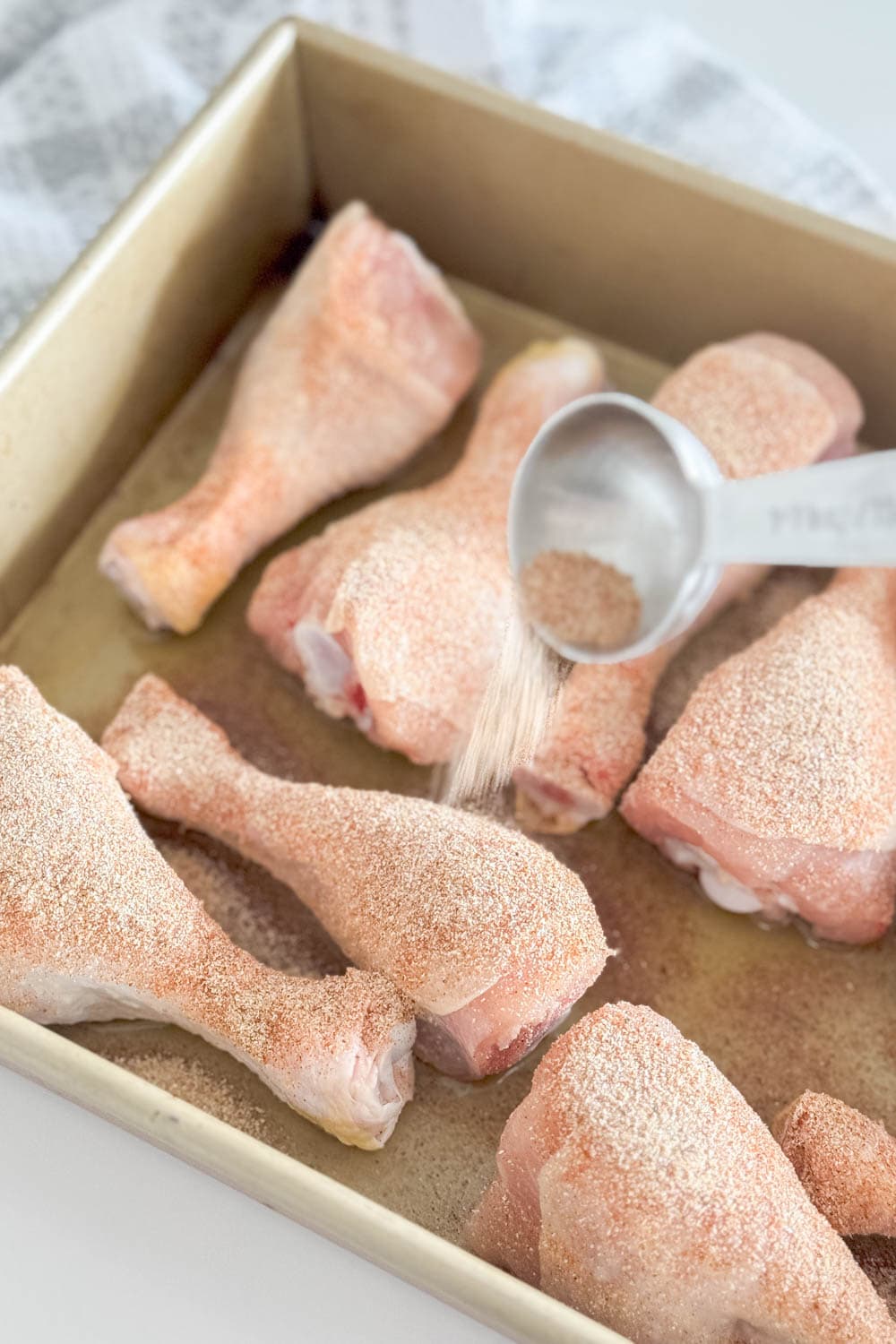 Adding spices to raw drumsticks
