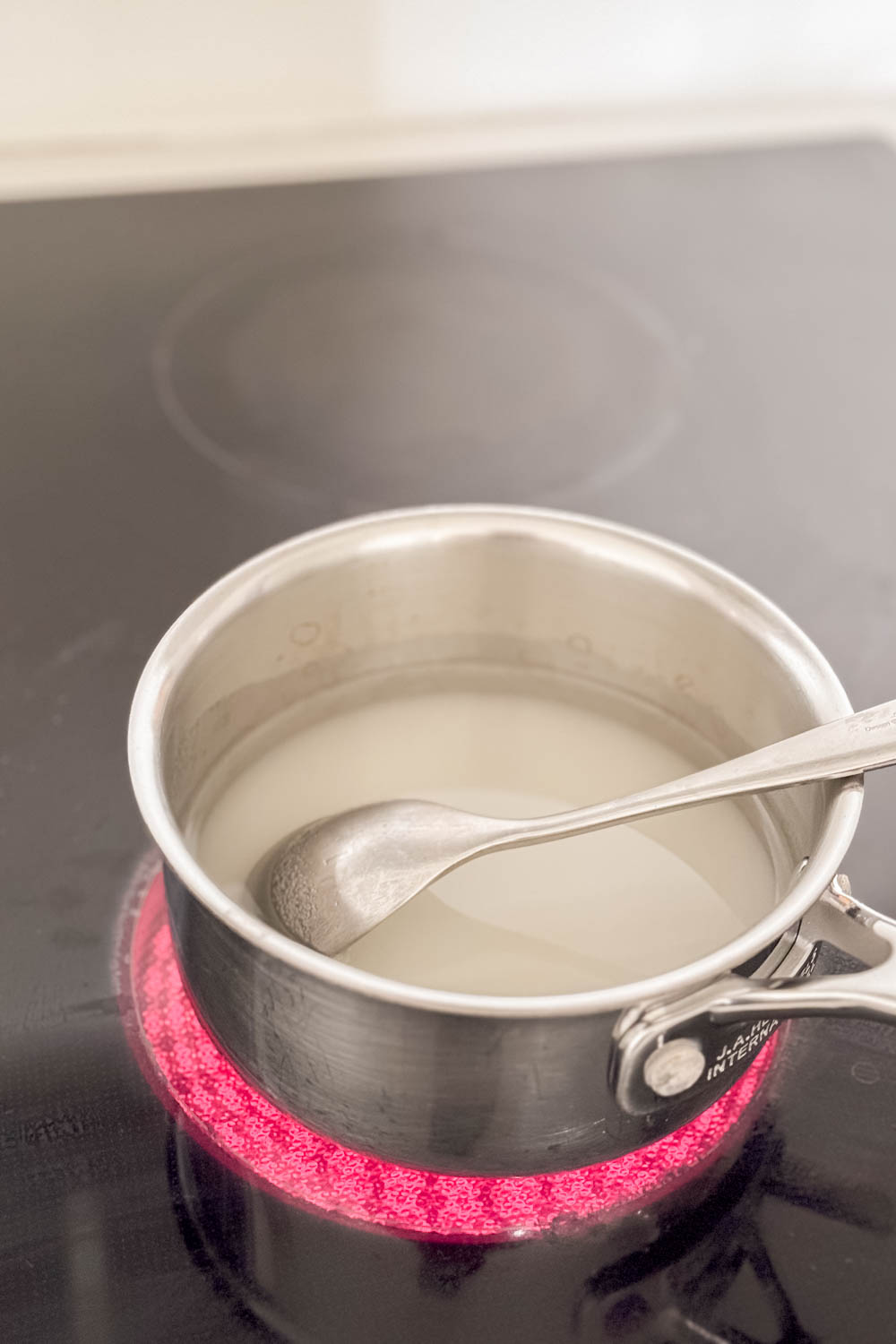 Sugar and water boiling in a saucepan to make homemade simple syrup